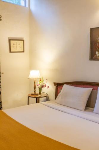 a bedroom with a bed and a table with a lamp at Seclude Ramgarh Taradale in Rāmgarh