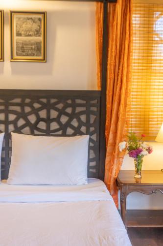 a bedroom with a bed and a table with a vase of flowers at Seclude Ramgarh Taradale in Rāmgarh