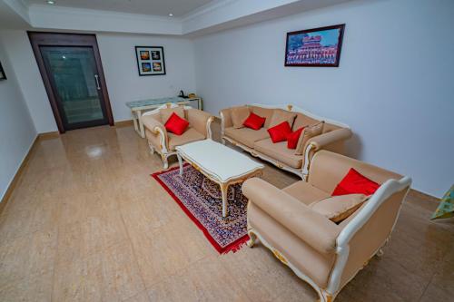 a living room with couches and red pillows at Hotel Sidhartha Chalakudy in Kizhake Chālakudi