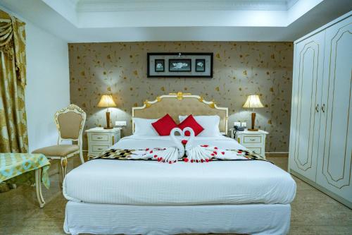 a bedroom with a large white bed with red pillows at Hotel Sidhartha Chalakudy in Kizhake Chālakudi