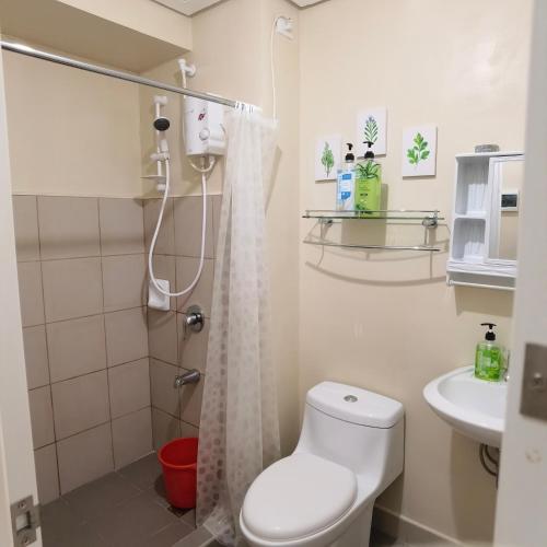 a white bathroom with a toilet and a sink at Avida Davao by davaobnb & Lemonique Homes in Davao City