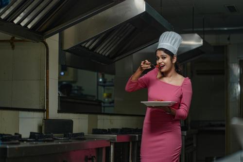 a woman in a chefs hat holding a plate of food at Hotel Sidhartha Chalakudy in Kizhake Chālakudi