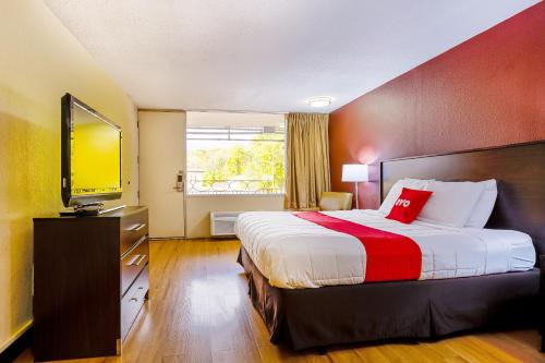 een hotelkamer met een bed en een flatscreen-tv bij OYO Hotel Moline Downtown IL I-74 North in Moline