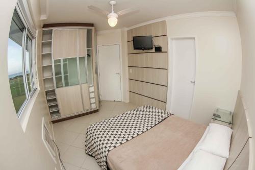 1 dormitorio pequeño con 1 cama y TV en Ingleses Ocean View, en Florianópolis