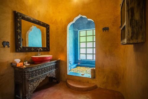 a bathroom with a red sink and a window at juSTa Morjim Beach Resort Goa - 80 Steps from Morjim Beach in Morjim