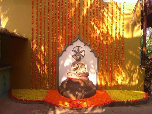 a statue of a buddha in a room with lights at juSTa Morjim Beach Resort Goa - 80 Steps from Morjim Beach in Morjim