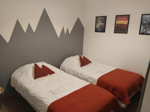 - 2 lits dans une chambre avec des montagnes sur le mur dans l'établissement Logement cosy 4/6 pers - quartier historique calme, à Cauterets