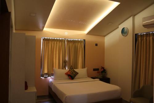 a hotel room with two beds and a window at Pooja Villa Suites-Rooms and Pool, Igatpuri in Igatpuri