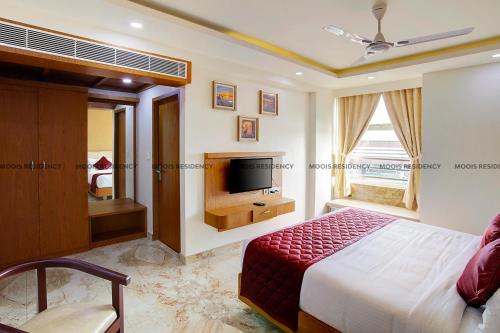 1 dormitorio con 1 cama y TV de pantalla plana en Moois Residency, en Kannur