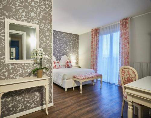 a hotel room with a bed and a mirror at Hotel Clodia - Adults Only in Sirmione
