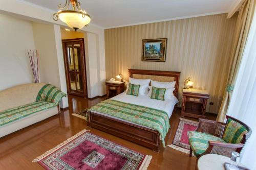 a hotel room with a bed and a chair at Vila Paris Boutique Hotel in Bucharest