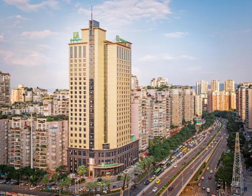 een hoog geel gebouw in een stad met verkeer bij Holiday Inn Chongqing Guanyinqiao, an IHG Hotel in Chongqing