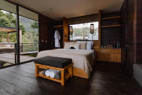 a bedroom with a large bed and a balcony at Munduk Cabins in Munduk