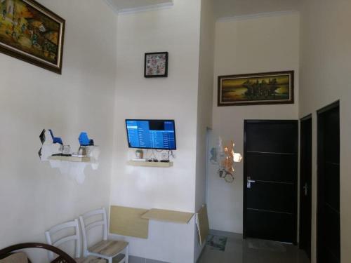 a room with a white wall with a tv and a box at Vila Bandungan in Bandungan