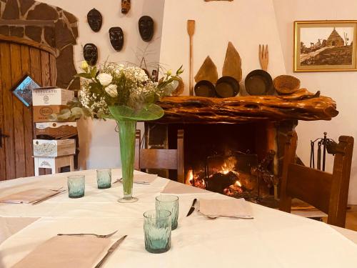 a table with a vase of flowers and a fireplace at Il Nuraghe del lago Coghinas in Oschiri