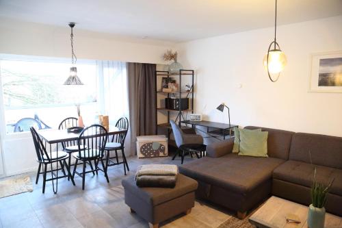 - un salon avec un canapé, une table et des chaises dans l'établissement Ferienwohnung Stöckel 2, à Cuxhaven