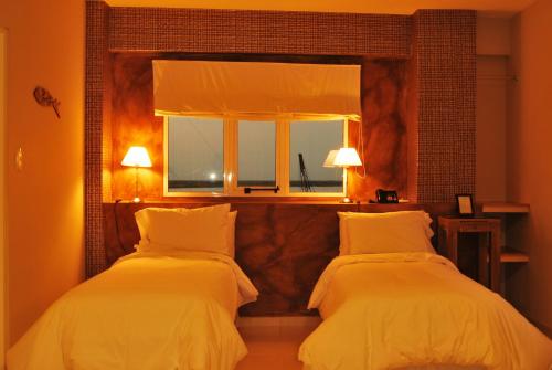 two beds in a room with a mirror at La Rozada Suites in Corrientes