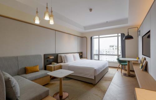une chambre d'hôtel avec un lit et un canapé dans l'établissement Holiday Inn Chongqing Guanyinqiao, an IHG Hotel, à Chongqing