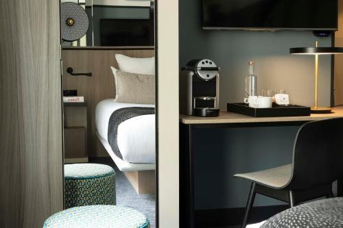 Cette chambre comprend un lit et un bureau avec une chaise. dans l'établissement Hôtel Opéra Liège, à Paris