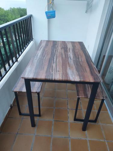 a wooden table sitting on top of a balcony at Casa Beatriz in Cala San Vicente