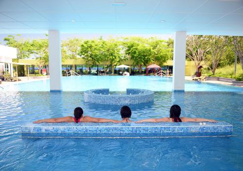 two women in the water at a swimming pool at The Orchard Resort & Spa Melaka I World Spa Awards Winner I Free Access to Outdoor Spa Pool in Melaka