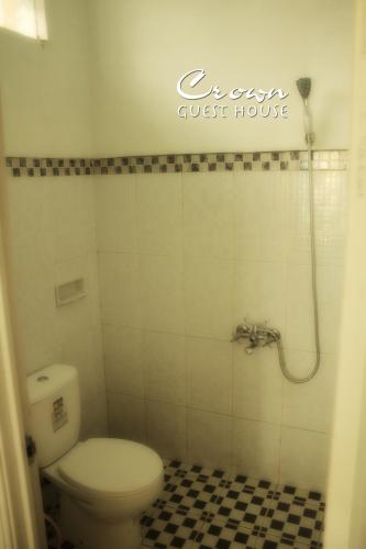 a bathroom with a toilet and a shower at Crown Guest House in Ambarawa
