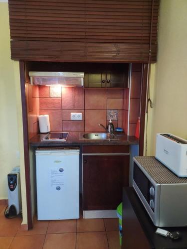 a small kitchen with a sink and a refrigerator at Casa Beatriz in Cala San Vicente