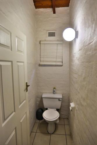 a bathroom with a white toilet in a room at One Jack Powell House- Classic family home steps away from the beach in Ballito