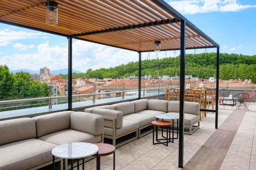 a patio with couches and tables on a roof at Hotel Ultonia in Girona