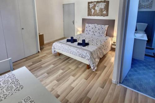 a bedroom with a bed and a wooden floor at Studio vue sur la roche, au calme Moustiers #1 in Moustiers-Sainte-Marie