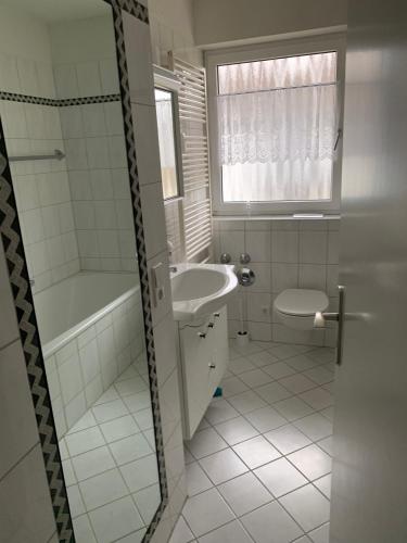 a bathroom with a sink and a tub and a toilet at Apartment "Wirtschaftswunder" in Rheinfelden
