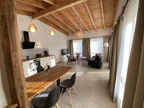 un soggiorno con un grande tavolo in legno e sedie di Ferienhaus AUSZEIT a Crottendorf