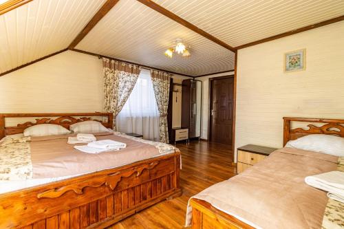 two beds in a room with wooden floors at Smerichka in Bukovel