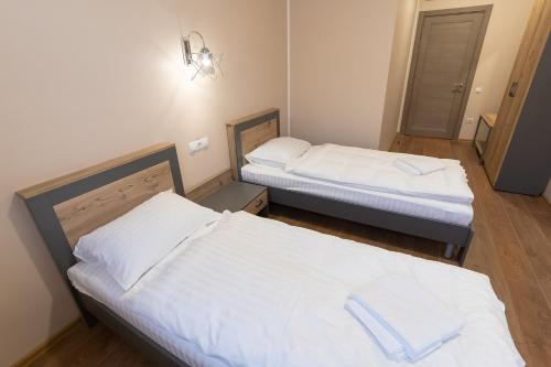 
two beds in a room with two lamps at Pivdenniy in Lviv
