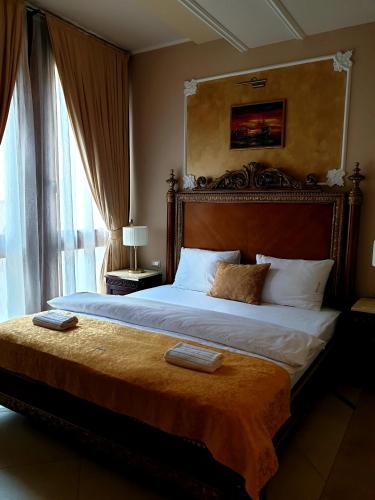 a bedroom with a large bed with a headboard at Arbia Dorka Heritage Palace in Varaždin