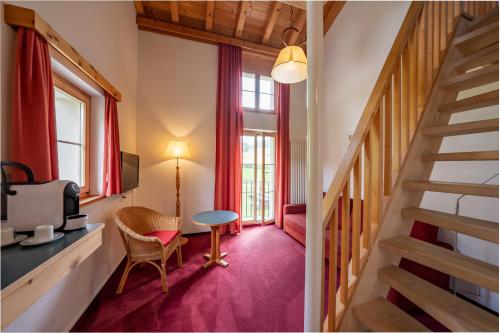 a room with a staircase and a table and chairs at Hotel Chesa Pool in Sils Maria