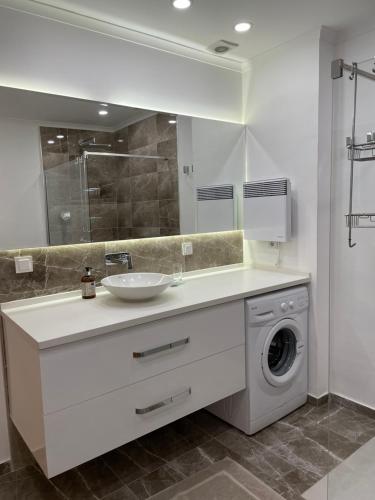 a bathroom with a sink and a washing machine at Beach House With Direct Access to Private Beach Near Bodrum in Çamlık