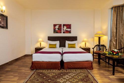a hotel room with two beds and a table and a bed at GOODWILL HOTEL in New Delhi