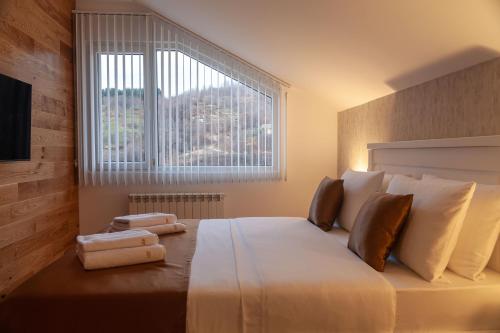 a bedroom with a large bed with a large window at Modern Mountain - Apartman 401 in Kolašin