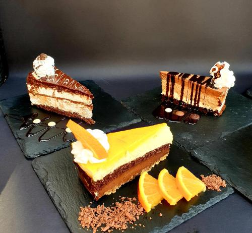 three different types of cakes sitting on plates at Arbia Dorka Heritage Palace in Varaždin