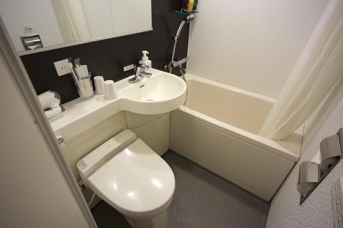 a small bathroom with a toilet and a sink at Vessel Inn Hakata Nakasu in Fukuoka