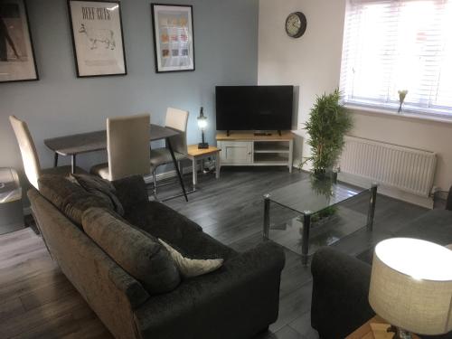 a living room with a couch and a table at 3 Smart TVs, Sleeps 3, VAN PARKING, Fast WIFI in Corby