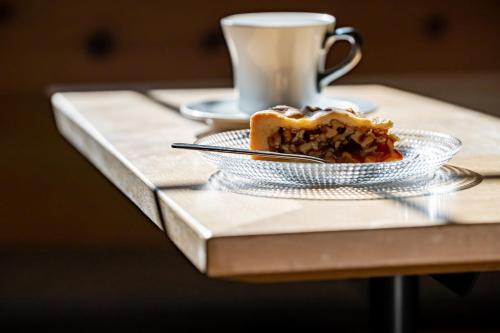 a piece of cake and a cup of coffee on a table at Hotel Chesa Pool in Sils Maria