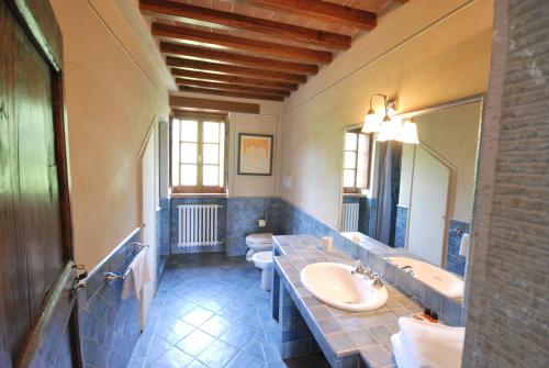 a bathroom with two toilets and a sink and a mirror at Fattorie di Celli in Poppi