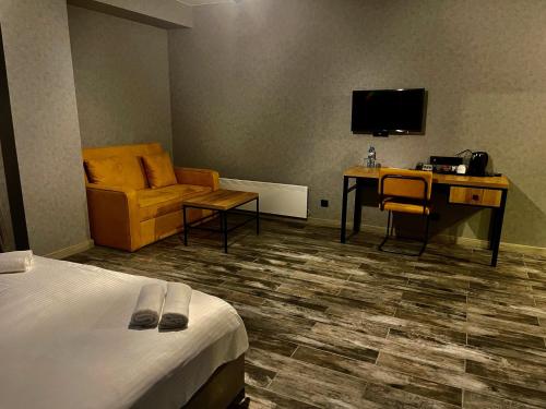 a hotel room with a bed and a couch and a desk at Gudauri Loft Hotel in Gudauri