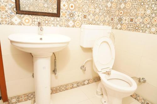 a bathroom with a toilet and a sink at Shimla Pines Homestay in Shimla