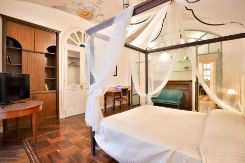 a bedroom with a canopy bed and a desk at Kriò Suite in Salerno