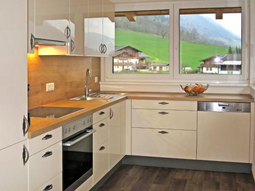 a kitchen with white cabinets and a sink and a window at Apartment Ingrid - FUC170 by Interhome in Fusch an der Glocknerstraße