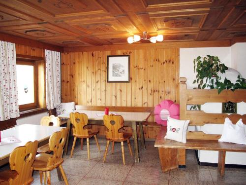 ノイキルヒェン・アム・グロースヴェンエーディガーにあるHoliday Home Moosen - NKI210 by Interhomeの木製の壁のダイニングルーム(テーブル、椅子付)