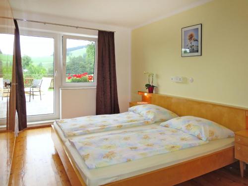 ein Schlafzimmer mit einem Bett und einem großen Fenster in der Unterkunft Holiday Home Mayrhofer - MON240 by Interhome in Oberwang
